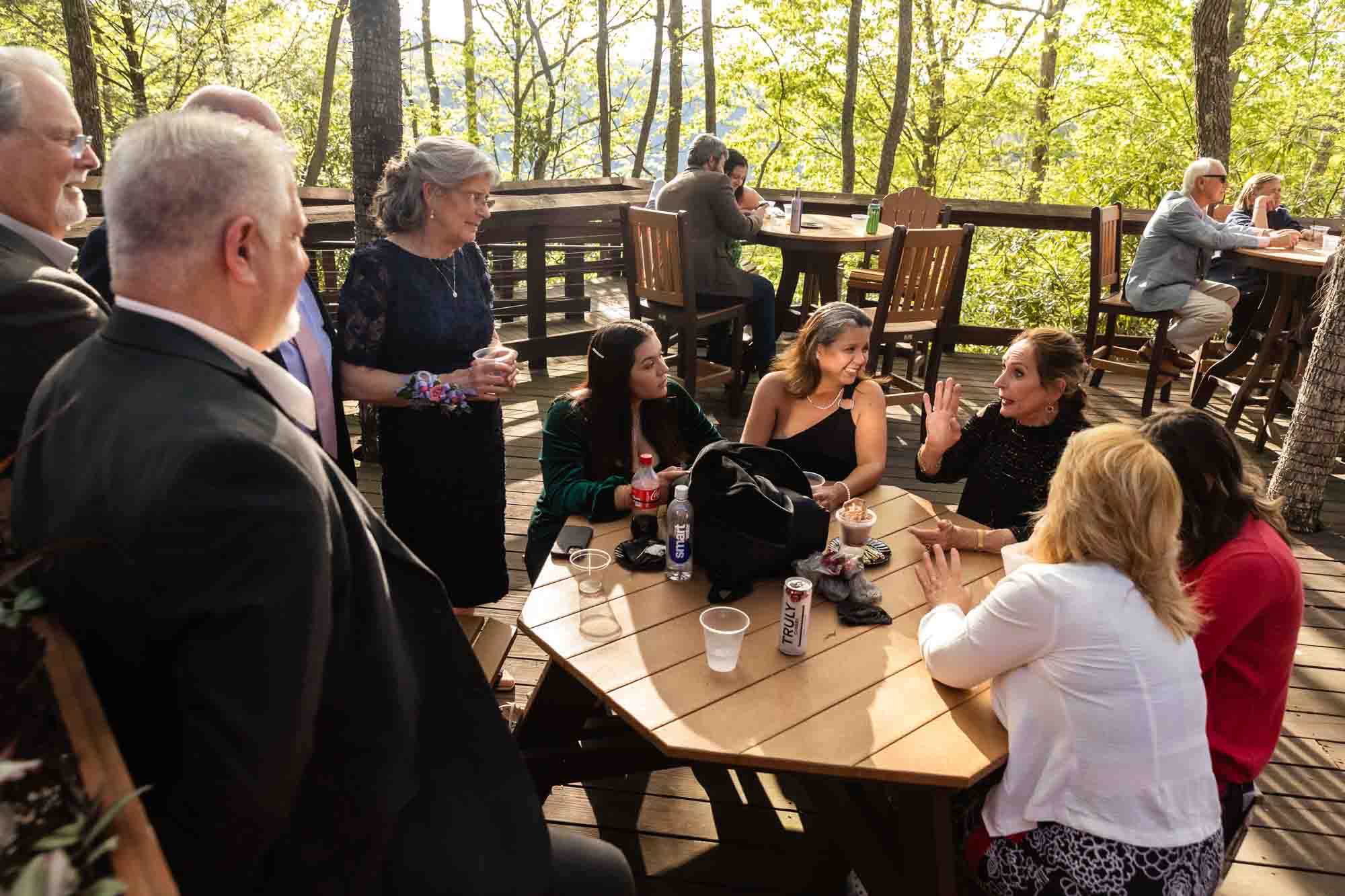 guests laugh together on a patio at sunset, image captured by pittsburgh documentary wedding photographer Pamela Anticole